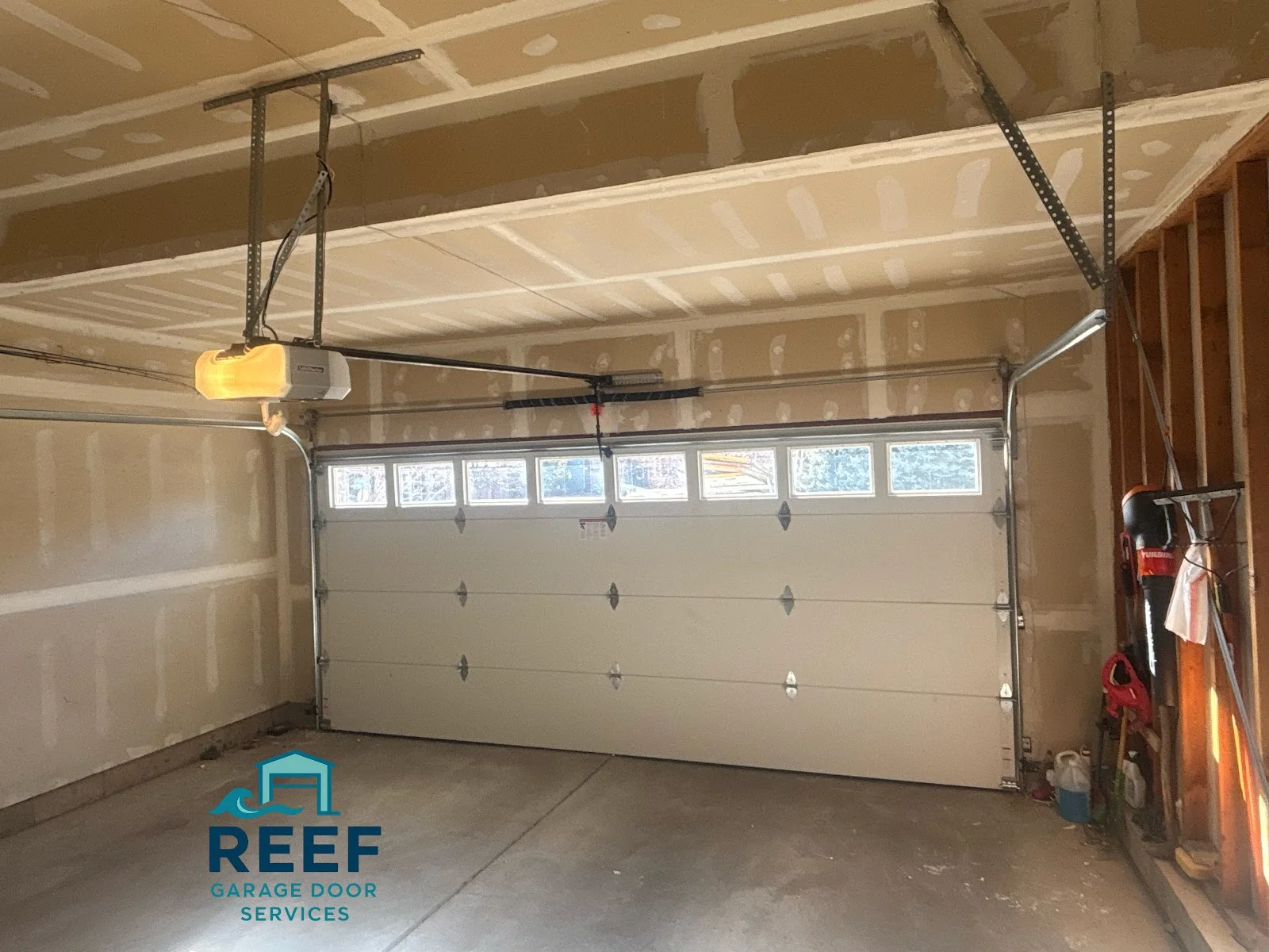 White sectional garage door with a row of upper windows